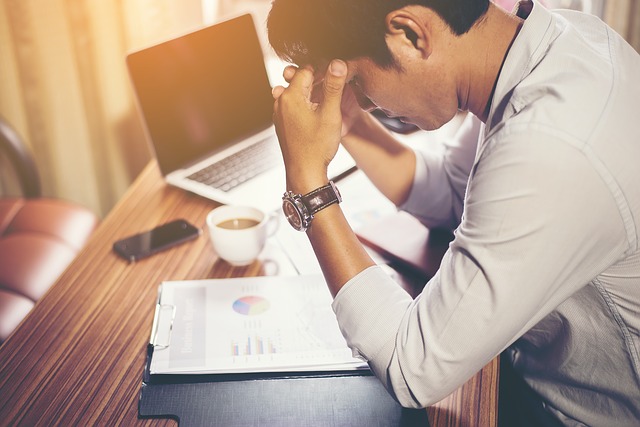 A man reviewing a chart of accounts, looking stressed out.